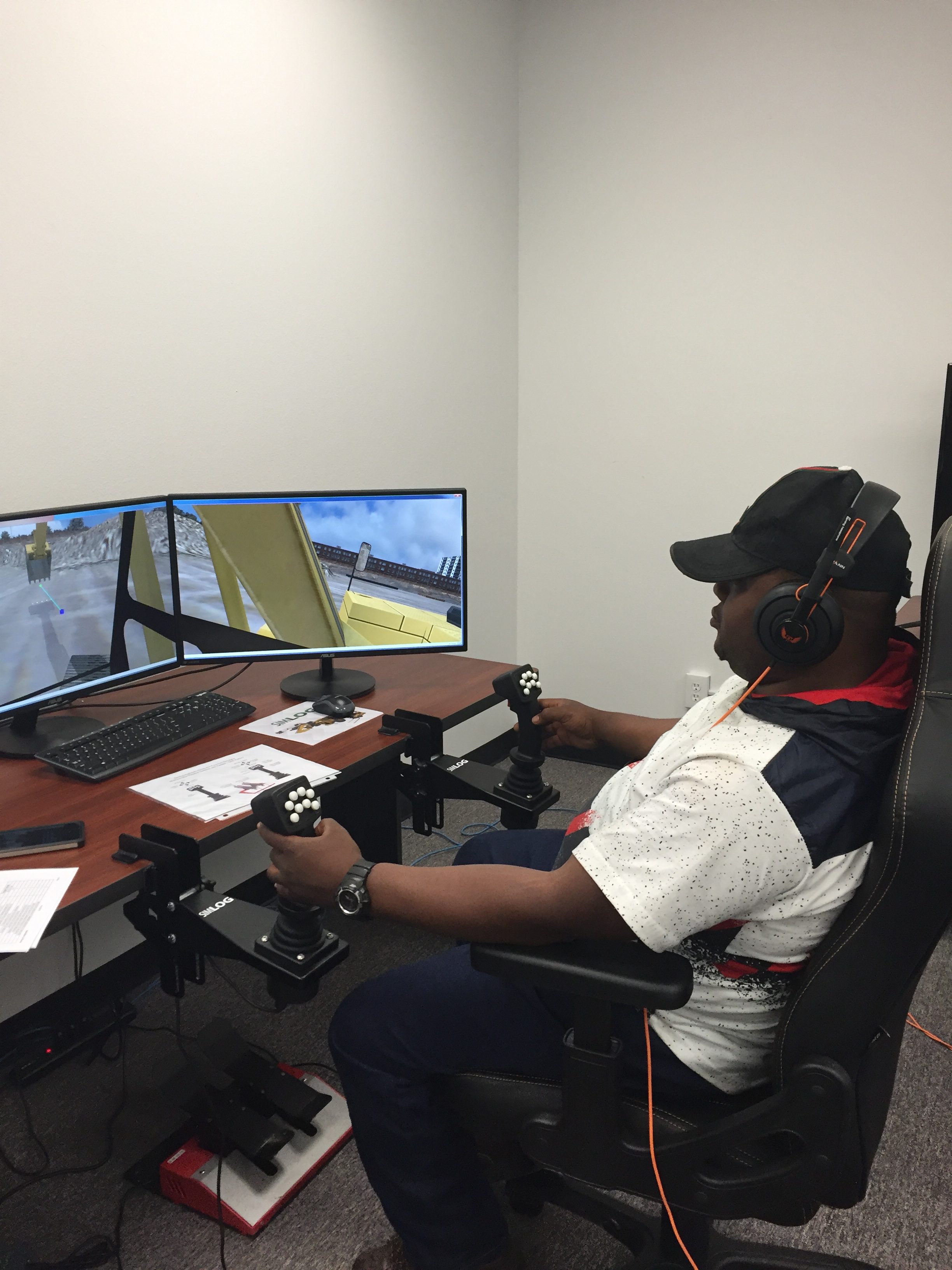 A student practices using an excavator simulator.