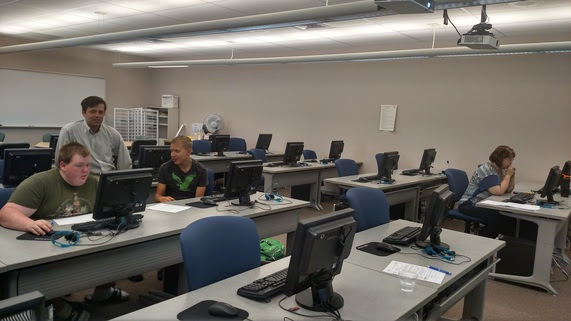  A teacher guides students in a computer lab as they learn how to code.