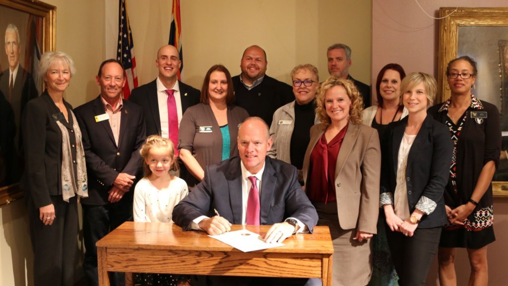 Superintendent Balow, WDE staff, and community college representatives stand around Governor Mead following the proclamation signing.