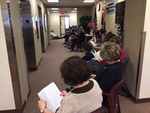 WDE staff sit in the hallway reading books.