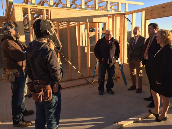 Students from Rawlins High School stand in a home they are constructing and describe the project to State Superintendent Jillian Balow and CCSSO Executive Director Chris Minnich.