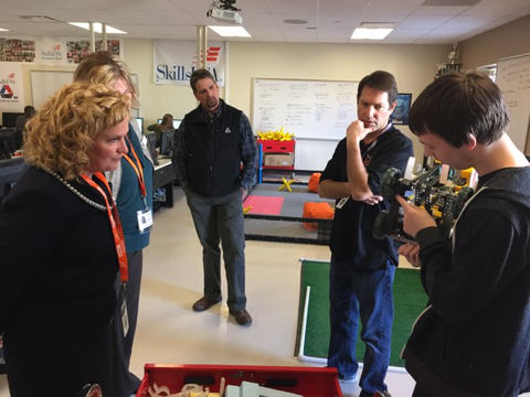 A student shows the progress on his robot to State Superintendent Jillian Balow, and other staff from the WDE and local school district.