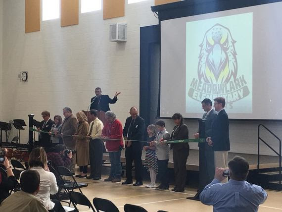 Students, school board members and the district superintendent cut the ribbon to open Meadowlark Elementary School inside their gym.