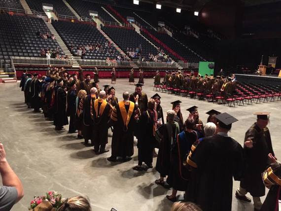 Graduates walk past a line of professors and dignitaries during their commencement ceremony at the Casper Events Center.