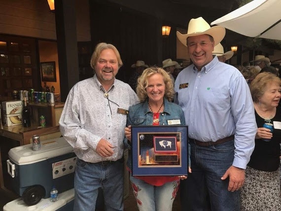 State Superintendent Jillian Balow holds a framed flag of the State of Wyoming with Laramie County Commissioners Ron Kailey and Troy Thompson at the Governor's residence.