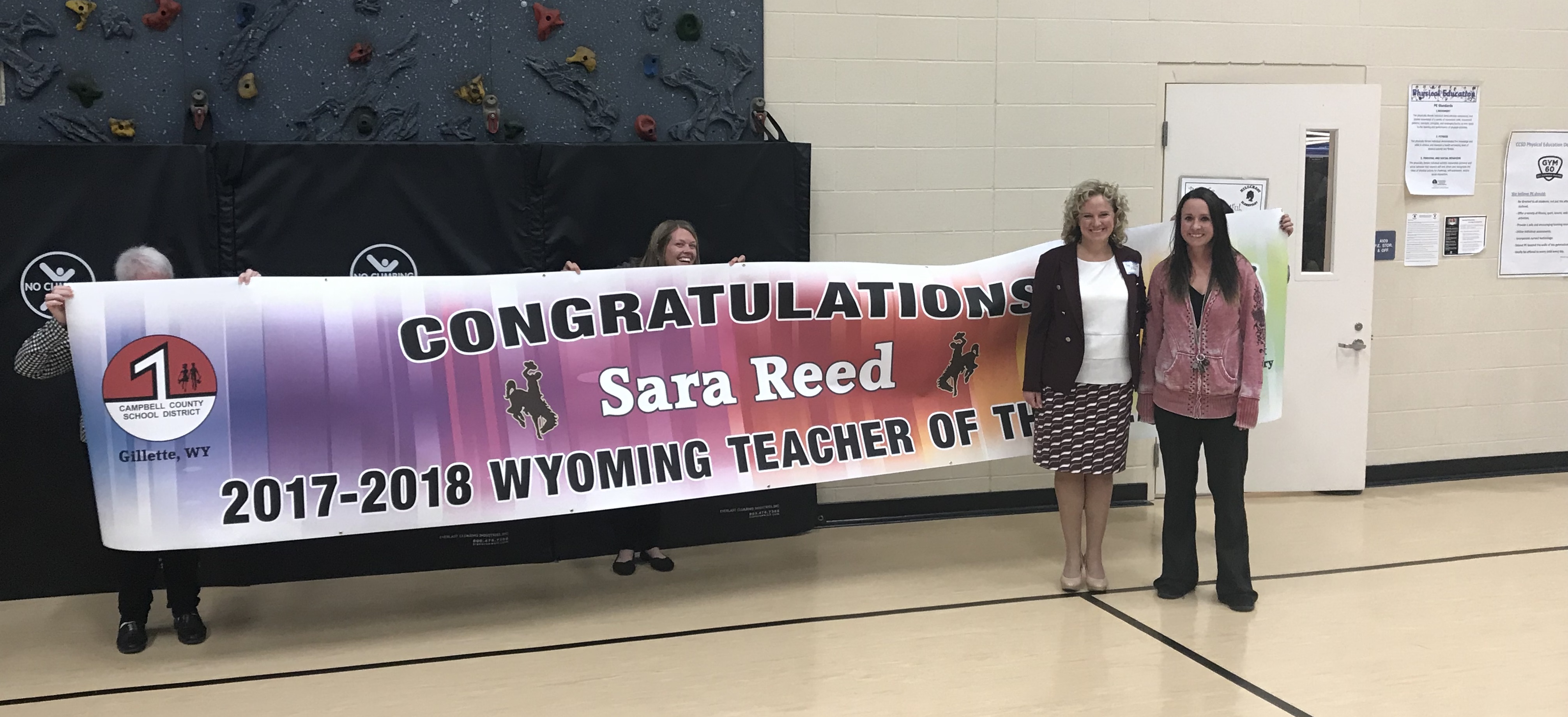 State Superintendent Jillian Balow stands with 2018 Teacher of the Year Sara Reed in front of a banner with reads, "Congratulations Sara Reed, 2017-2018 Wyoming Teacher of the Year, Campbell County School District #1, Gillette, WY"