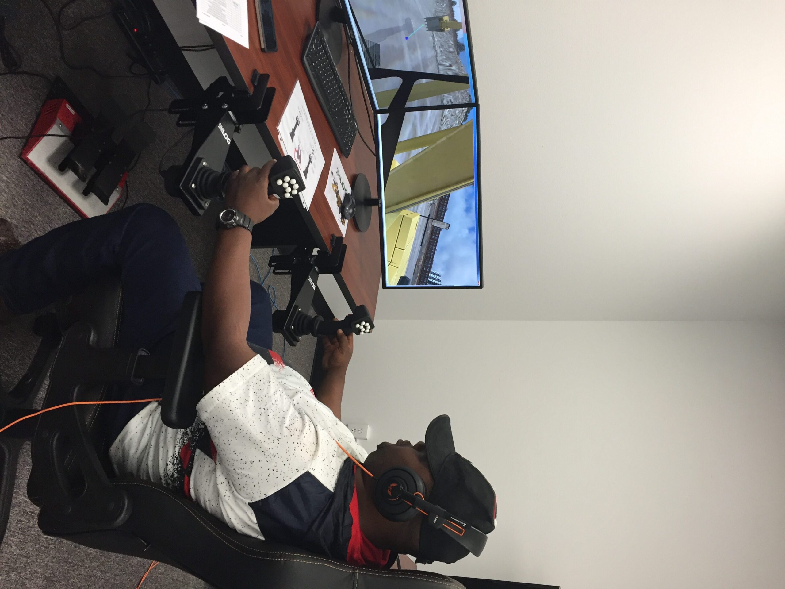 A student practices using an excavator simulator.