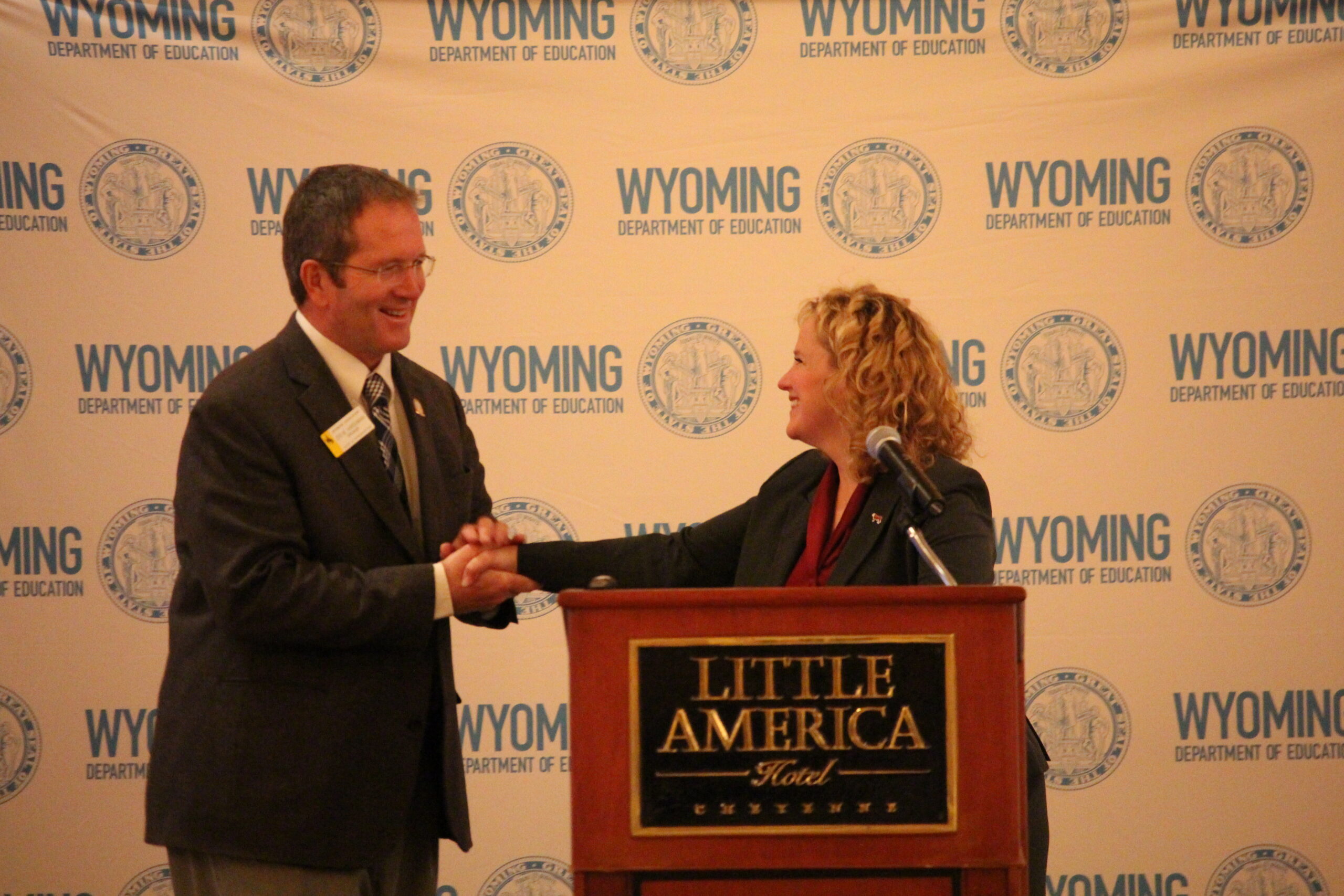 House Speaker Steve Harshman shakes hands with State Superintendent Jillian Balow as he arrives at the podium to speak at the policy summit.